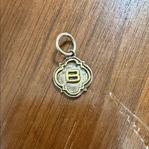 This is a Waxing Poetic quatrefoil insignia initial charm